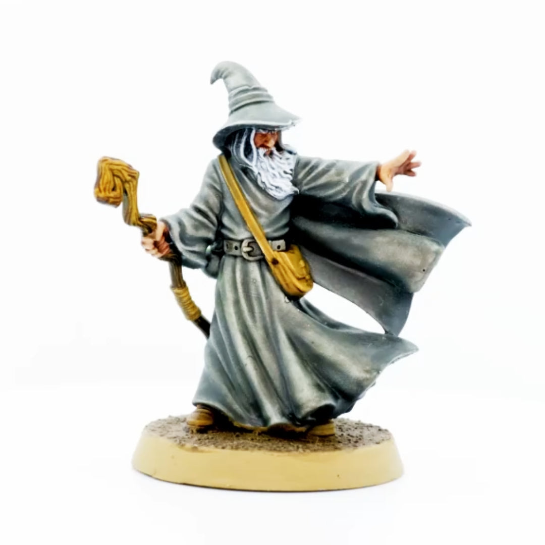 Load video: Video of Amlund the grey Wizard Miniature his hand out stretched and a staff in his other hand.